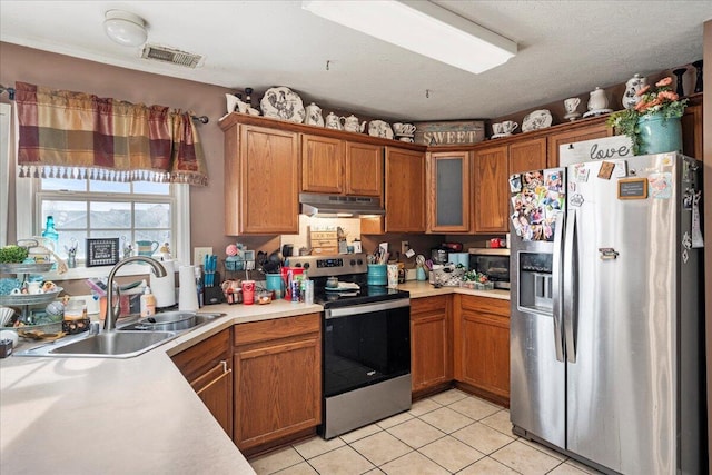 kitchen featuring visible vents, under cabinet range hood, a sink, appliances with stainless steel finishes, and light countertops