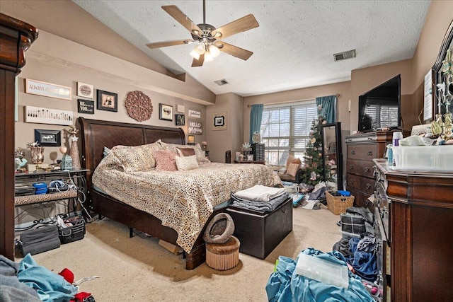 carpeted bedroom with visible vents, lofted ceiling, a textured ceiling, and a ceiling fan