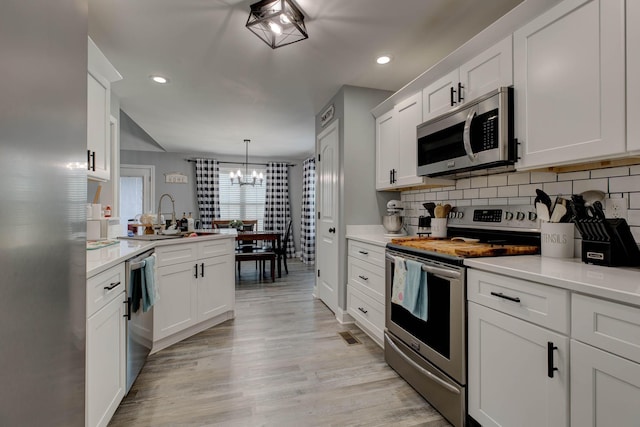 kitchen with stainless steel appliances, backsplash, and light countertops