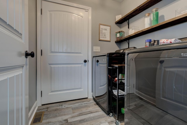 laundry area featuring visible vents, independent washer and dryer, laundry area, and light wood finished floors