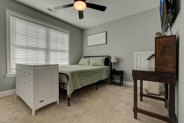 bedroom featuring visible vents, light colored carpet, baseboards, and multiple windows