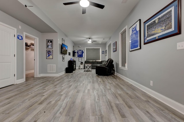 living area with ceiling fan, visible vents, baseboards, and wood finished floors