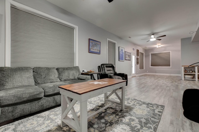 living room with baseboards, a ceiling fan, and wood finished floors