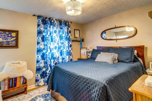 bedroom featuring a textured ceiling and baseboards