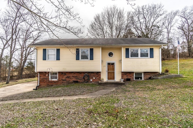 raised ranch featuring driveway and a front lawn