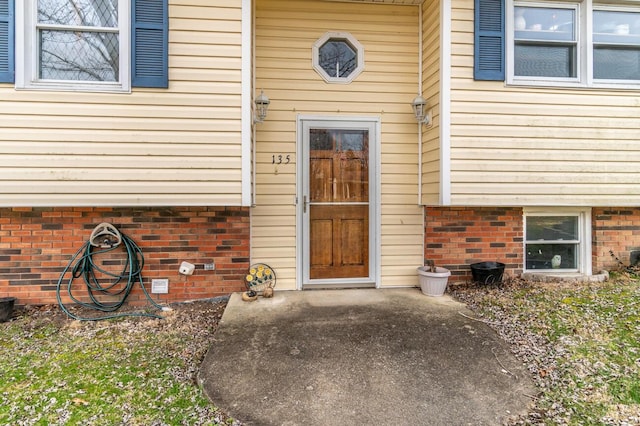 property entrance featuring brick siding