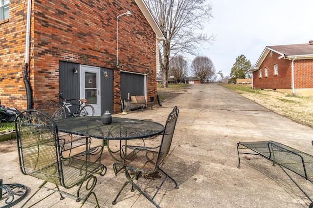 view of patio with outdoor dining area and driveway