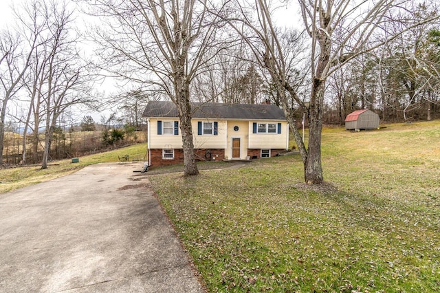 split foyer home with an outbuilding, driveway, a front lawn, and a shed