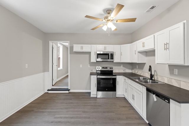 kitchen featuring visible vents, a sink, dark countertops, white cabinetry, and stainless steel appliances