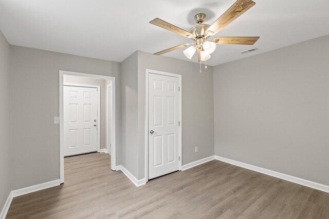 spare room with visible vents, baseboards, light wood-style flooring, and a ceiling fan