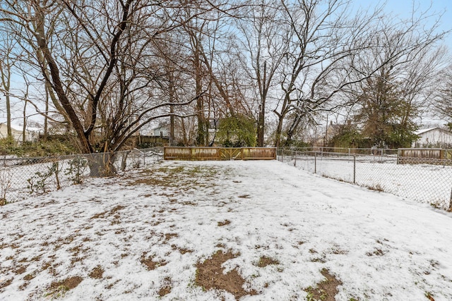 yard layered in snow featuring a fenced backyard