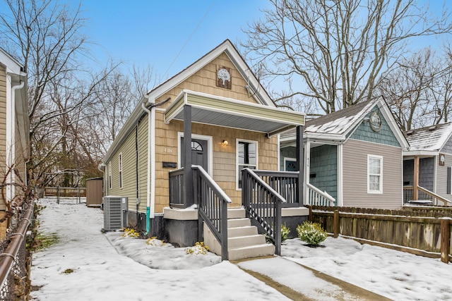 view of front of property with a porch, cooling unit, and fence