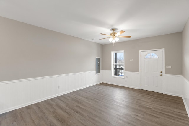 entryway with a wainscoted wall, dark wood-type flooring, visible vents, and ceiling fan