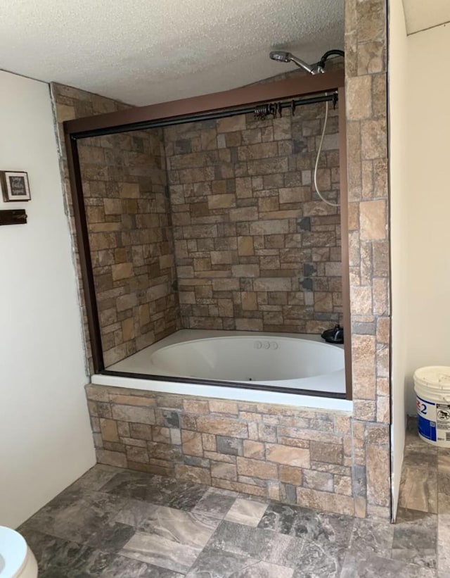 full bath with tiled shower / bath combo and a textured ceiling