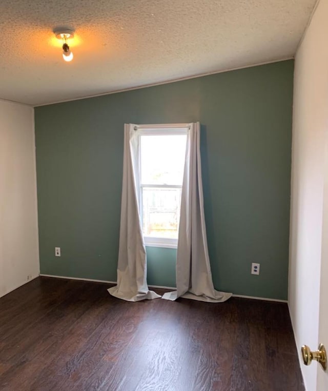 empty room with a textured ceiling and wood finished floors