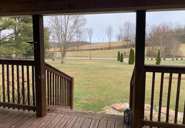 wooden deck featuring a rural view and a lawn