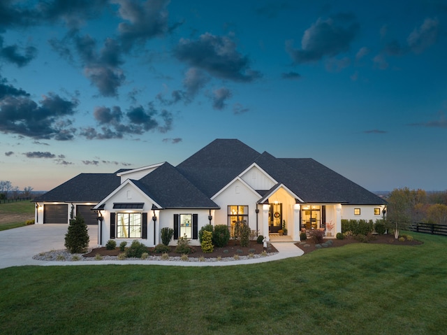 modern farmhouse style home featuring a yard, roof with shingles, concrete driveway, and fence