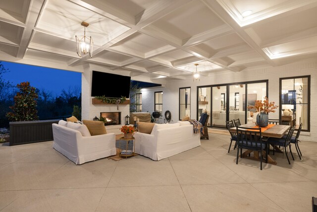 living area with a large fireplace, coffered ceiling, beamed ceiling, and an inviting chandelier