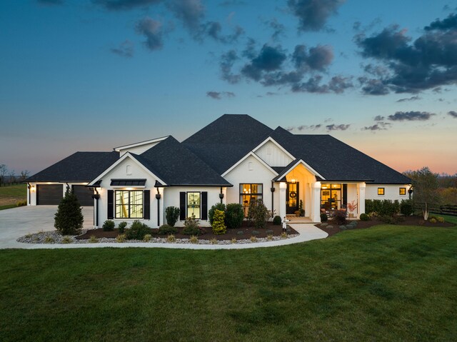 modern farmhouse style home featuring driveway, a lawn, an attached garage, and board and batten siding