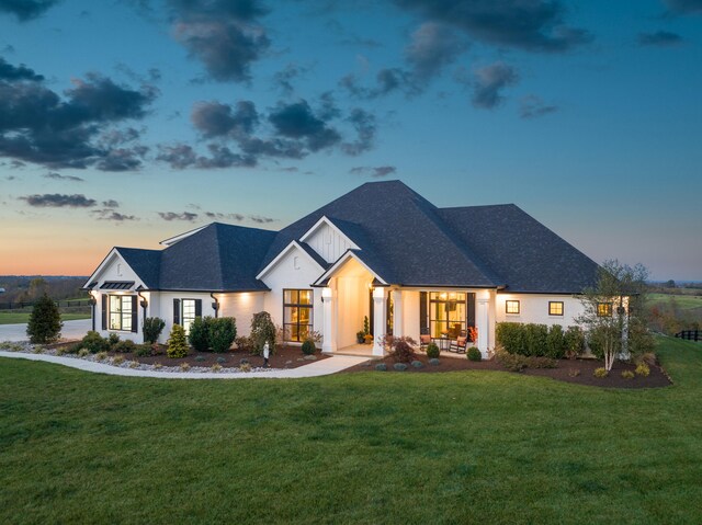 modern farmhouse style home with a shingled roof and a front yard