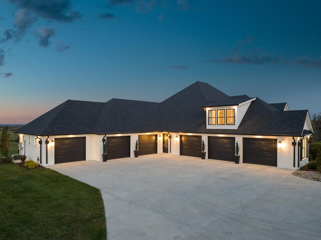 modern farmhouse featuring concrete driveway, a front lawn, and a shingled roof