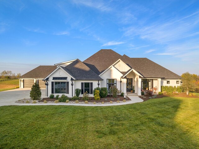 modern inspired farmhouse with roof with shingles, concrete driveway, board and batten siding, a garage, and a front lawn