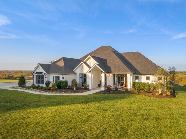 view of front facade featuring a front lawn and a shingled roof