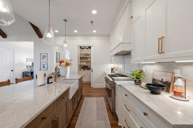 kitchen featuring dark wood-style floors, high end stainless steel range, backsplash, and white cabinetry