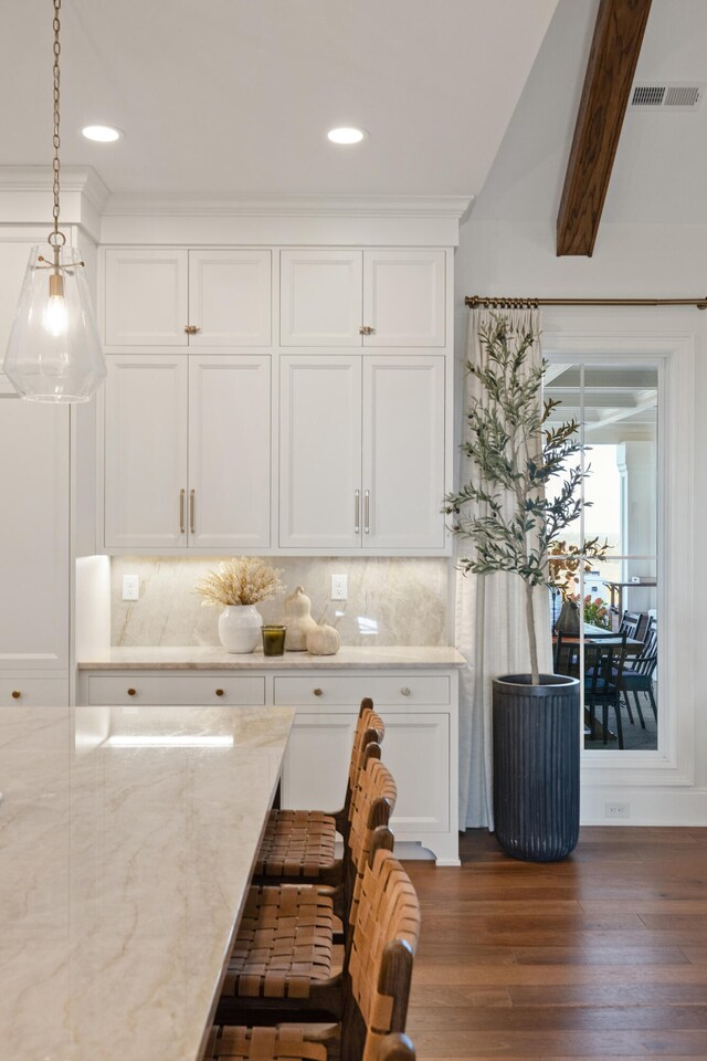 kitchen featuring dark wood-type flooring, decorative backsplash, visible vents, and white cabinets