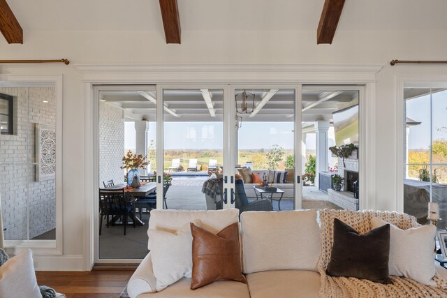 sunroom with a healthy amount of sunlight, a fireplace, and beam ceiling