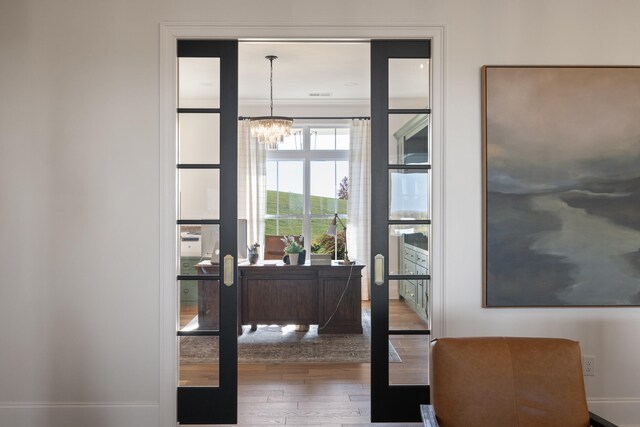 office area with a notable chandelier, baseboards, and wood finished floors