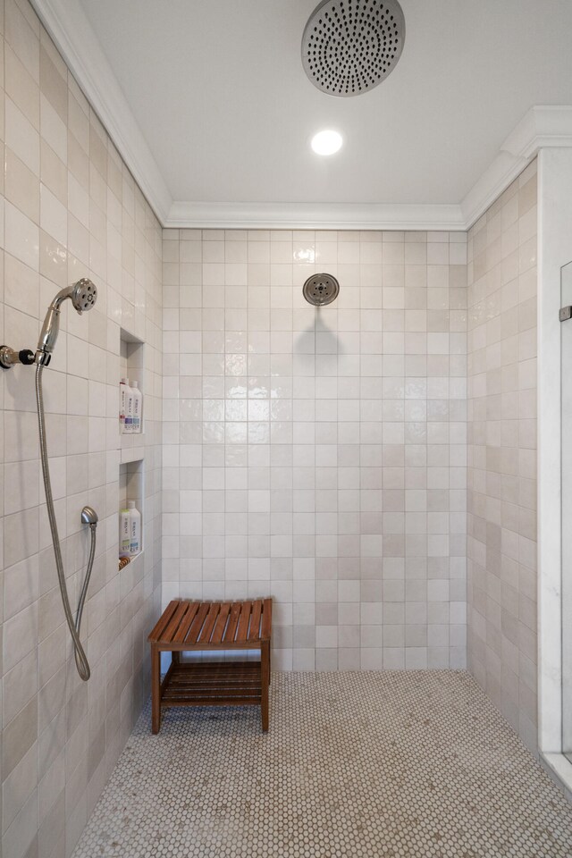 bathroom featuring crown molding and a tile shower