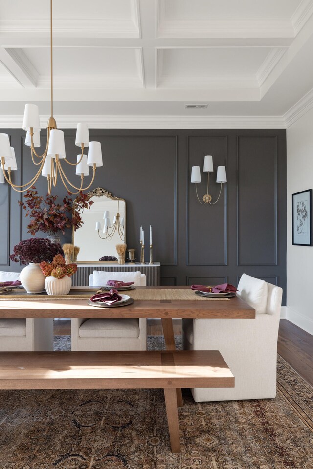 interior space with a notable chandelier, visible vents, ornamental molding, wood finished floors, and coffered ceiling