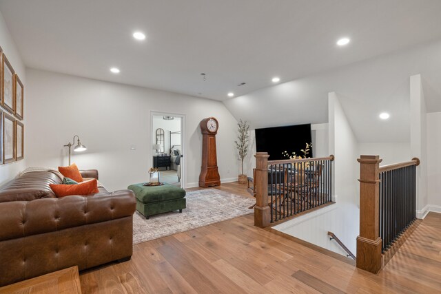 living room featuring lofted ceiling, recessed lighting, light wood-style flooring, and baseboards