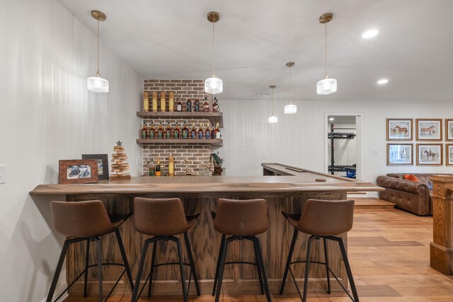 bar featuring wet bar, hanging light fixtures, recessed lighting, and wood finished floors