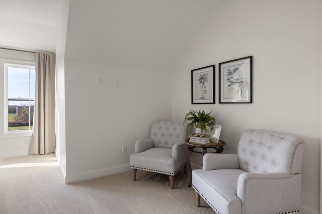 living area with baseboards, vaulted ceiling, and carpet flooring