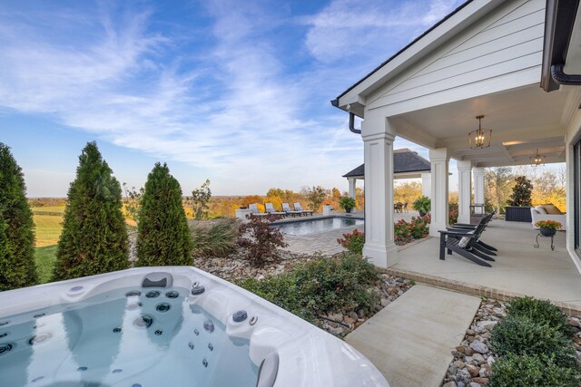 view of patio featuring a hot tub and an outdoor pool