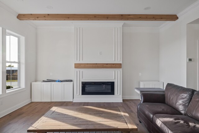 living area featuring light wood-type flooring, a glass covered fireplace, beamed ceiling, and baseboards