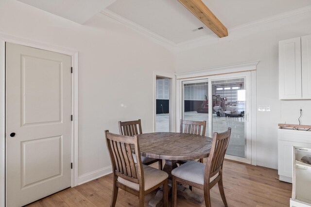 dining room with baseboards, visible vents, ornamental molding, light wood-style floors, and beam ceiling