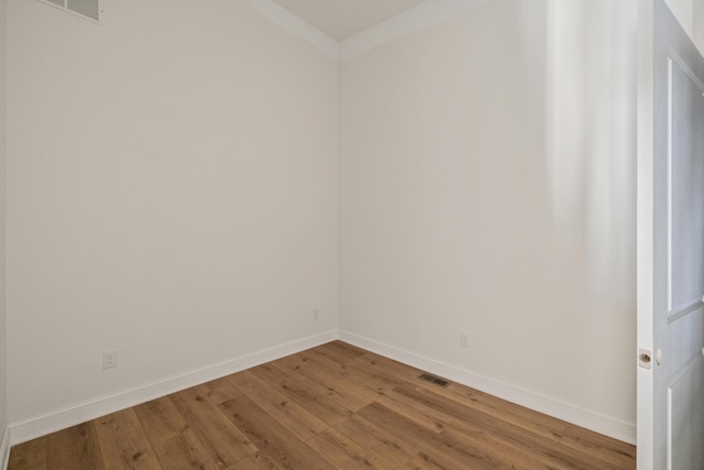 unfurnished room with hardwood / wood-style flooring, baseboards, and visible vents