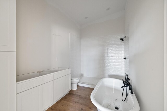 bathroom with a shower, a soaking tub, toilet, and wood finished floors