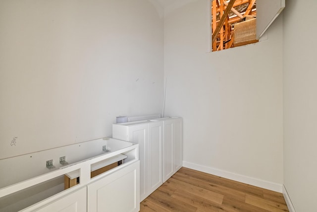 laundry room featuring light wood-style floors and baseboards