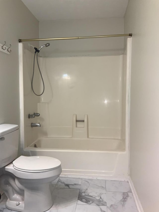 full bath featuring marble finish floor, shower / tub combination, toilet, and baseboards