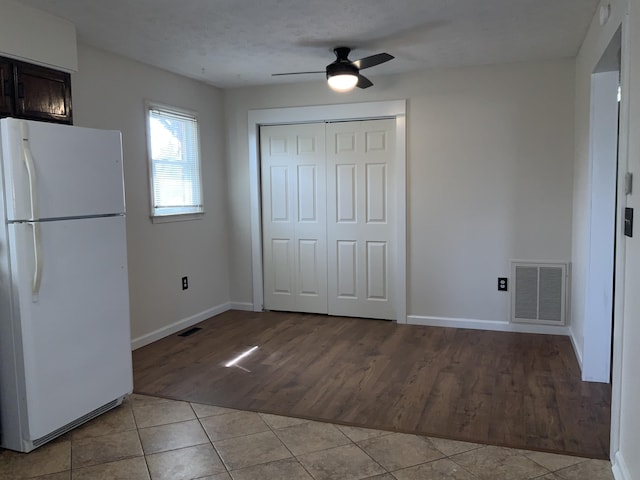 unfurnished dining area with visible vents, ceiling fan, baseboards, and light tile patterned floors