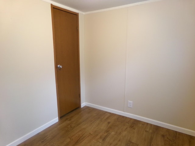 empty room featuring wood finished floors and baseboards