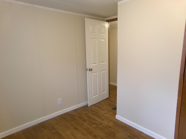 spare room with wood finished floors and baseboards