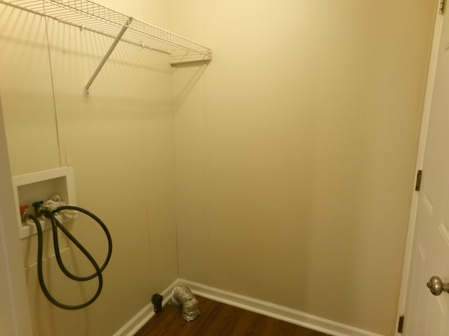 clothes washing area with dark wood-type flooring, washer hookup, laundry area, and baseboards