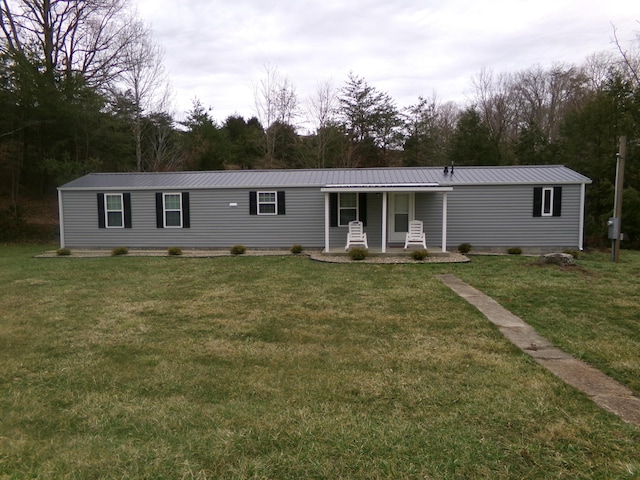 manufactured / mobile home with metal roof and a front lawn