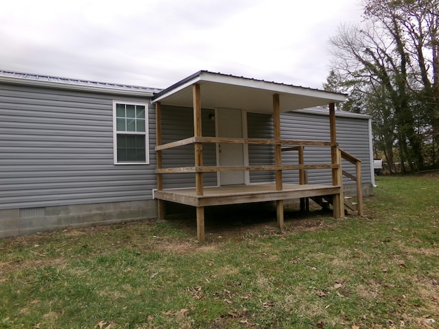 rear view of house with a yard, crawl space, and metal roof