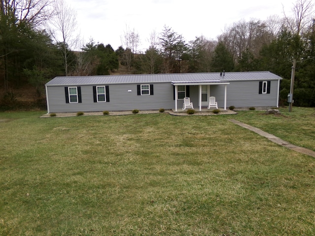 manufactured / mobile home featuring metal roof and a front lawn